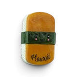 A novelty soap bar shaped like a Hawaiian roll of sushi, featuring a cute cartoon face and the word 'Hawaii' printed on it, set against a plain white background.